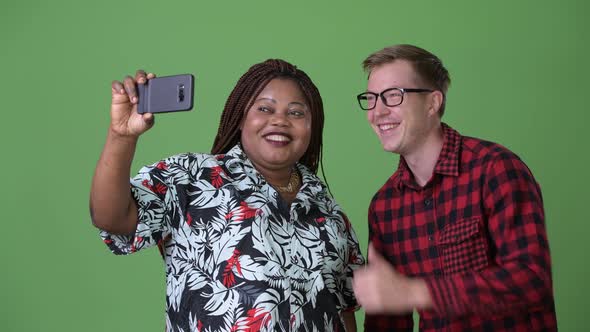 Overweight African Woman and Young Scandinavian Man Together Against Green Background