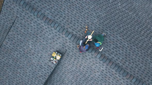 Aerial View of a Two Workers on the Roof Installing the Iron Chimney