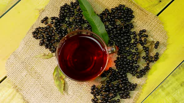 Red Tea From Fresh Black Berries In A Cup Top View On A Wooden Vintage Table. Elderberry Tea.