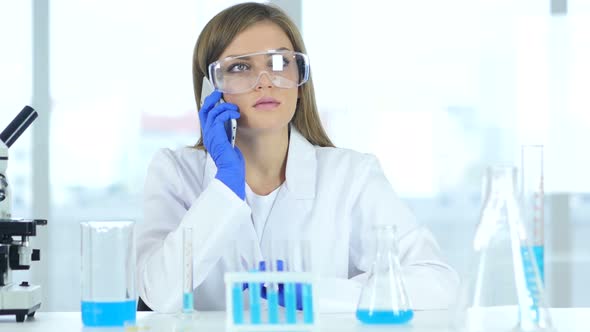 Female Scientist Talking on Phone in Laboratory