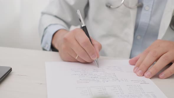 Doctor Writing The Medical History And Diagnosis On The Paper. close up