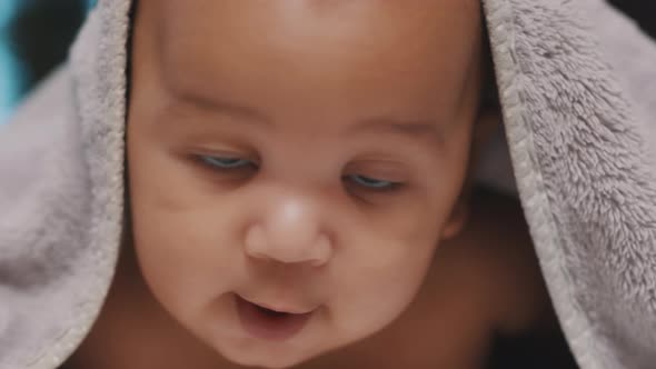 Close Up of Cute Black Baby with Head Covered with Fluffy Towel