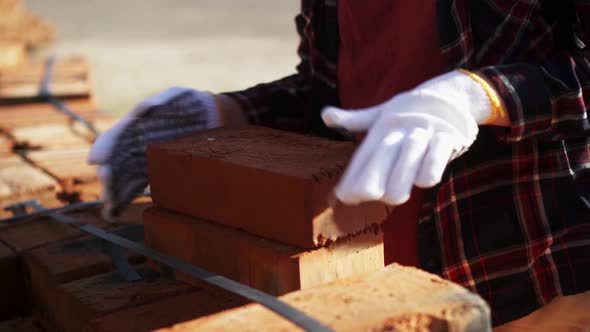 Woman Builder Carries Red Bricks, Building Material Brick Blocks For Building A Stack Of Warehouse