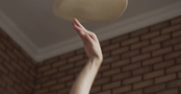 Cheerful male chef tossing dough