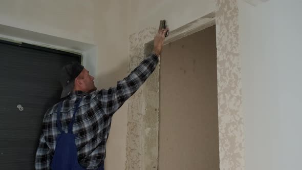 Wide View Footage of Worker Puts Decorative Plaster on the Wall Forming a Relief