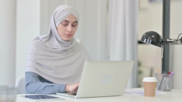 Attractive Young Arab Woman with Laptop Looking at Camera