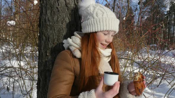 Red-Haired Teen Girl Standing At Tree And Having A Snack