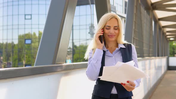 Portrait of Business Woman with Documents Calling Phone Outdoor