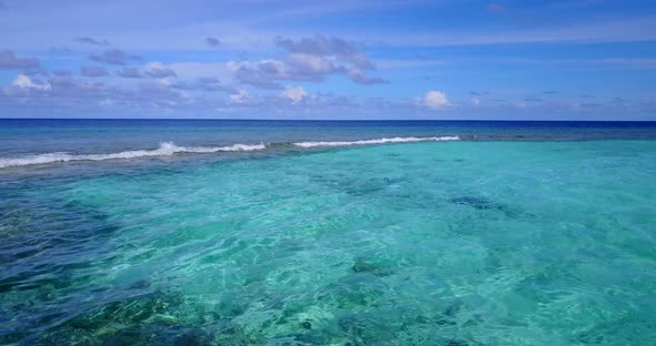 Wide angle above travel shot of a white sandy paradise beach and aqua turquoise water background in 