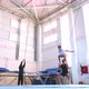 An Young Athlete is Doing an Air Back Flip on Safety Slings in the Gym - VideoHive Item for Sale