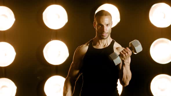 Athletic man workouts out in front of a wall of lights