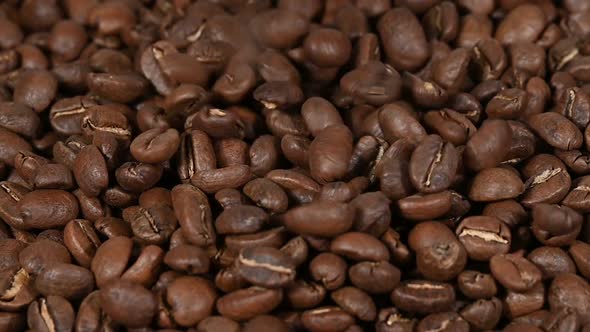 Background of pouring roasted coffee beans, falling on heap