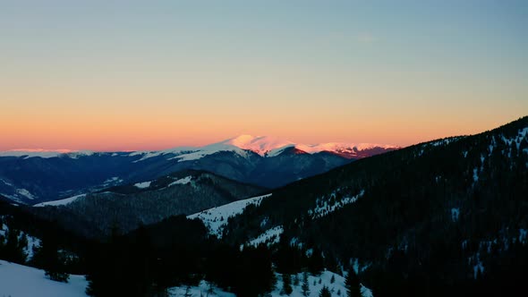 Flying above Winter Forest. Snow Covered Mountains. Beautiful Cinematic Landscape in Romania 