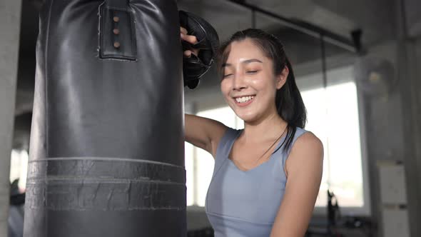 4K Asian sportswoman in sportswear wearing boxing gloves do boxing exercise at gym.