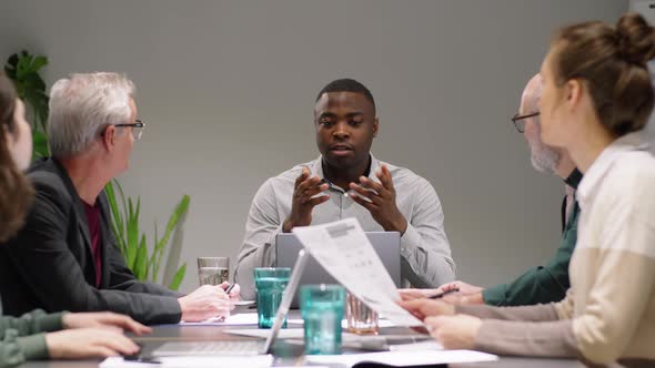 Mixed-Age Diverse Team of Coworkers Having Discussion at Office Meeting