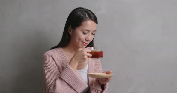 Woman having tea over gray background