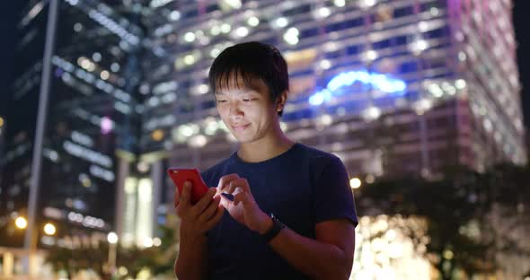 Asian Man use of mobile phone in city of Hong Kong at night