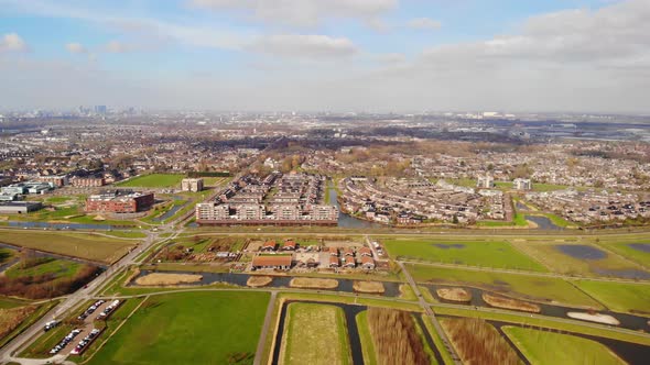 Aerial Pan Right View Across Barendrecht Green Fields And Town With Rotterdam Skyline In Distance