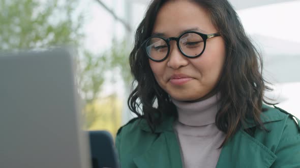 Asian Businesswoman Using Smartphone Outdoors