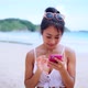 Portrait of Happy Smiling Woman Using a Mobile Phone on the Beach Posting a Picture Online - VideoHive Item for Sale