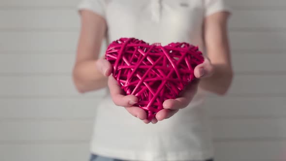 Girl Holding a Wickerwork in the Shape of a Heart