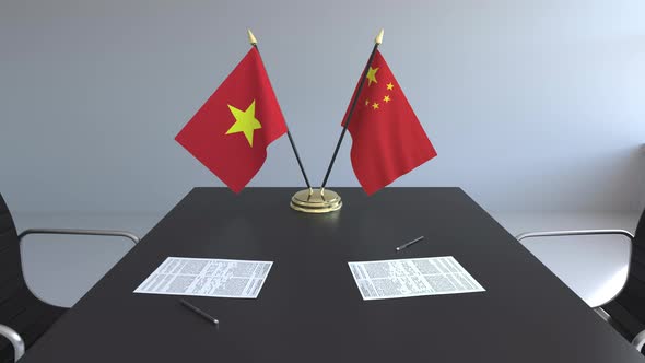 Flags of Vietnam and China on the Table