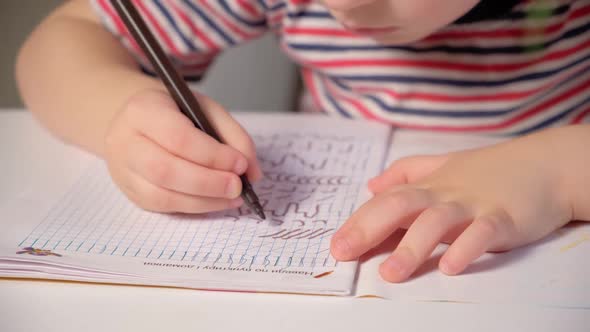 Preschool Child Learns to Write Writes Copybook Hands Closeup