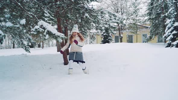 Cute little girl running in the snow among beautiful fir-trees in winter. alt