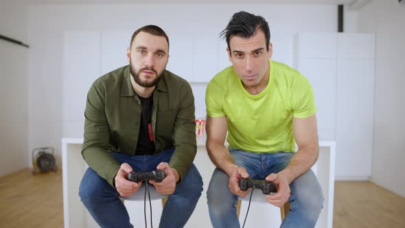 Point of View From TV of Two Absorbed Men Playing Video Game Using Game Consoles