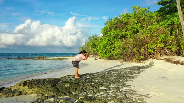 Girl sunbathes on tranquil coast beach journey by shallow lagoon and white sandy background of the M