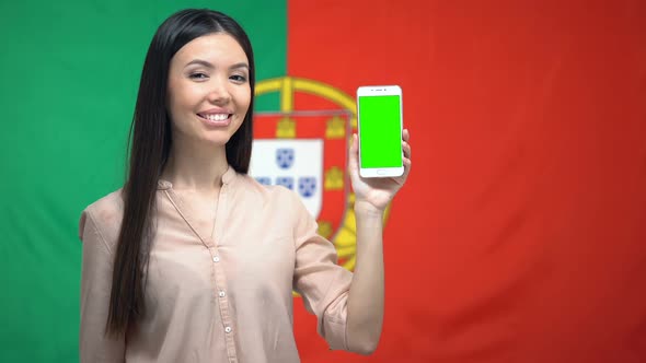 Female Showing Phone With Green Screen, German Flag on Background, Travel App