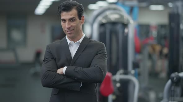 Portrait of Confident Middle Eastern Man in Suit Posing in Gym Indoors