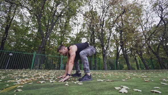 Athletic male training outdoor. Man doing strength training exercise pushup outdoor