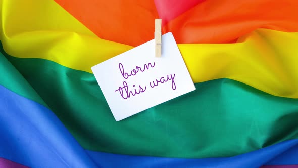 Zoom in Out Rainbow Flag with Text BORN THIS WAY Message on Paper Note