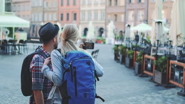 Back View of Man and Woman Making Selfie on Smartphone in the City Center