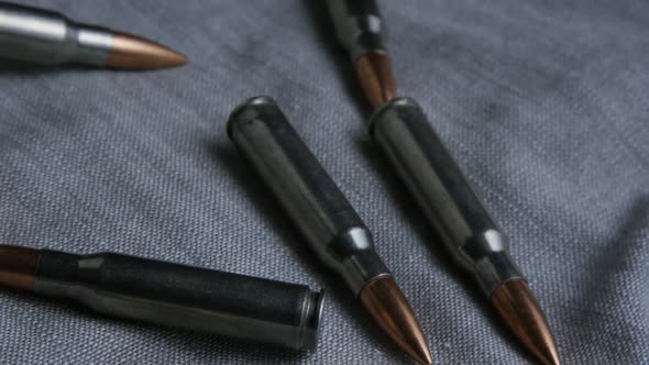 Cinematic rotating shot of bullets on a fabric surface 