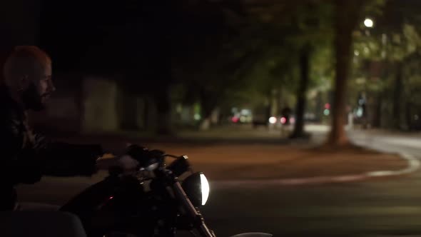 Side View of a Brutal Man Riding Fast His Motocycle By Night City Street