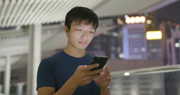 Man use of mobile phone in Hong Kong city at night