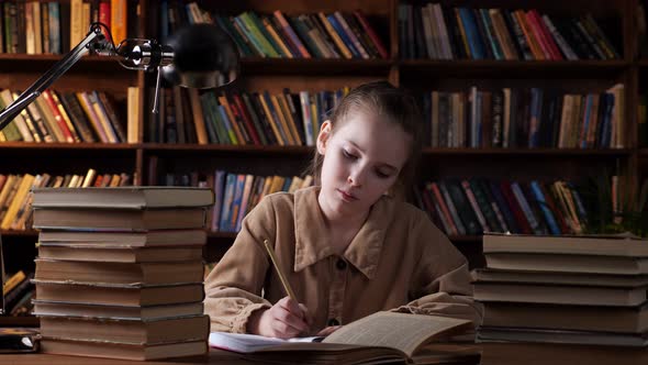 Thoughtful Schoolgirl Writes Home Task in Paper Notebook