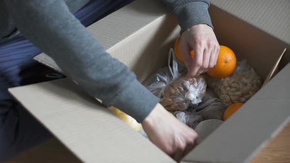 Man Examines Products Brought by Courier