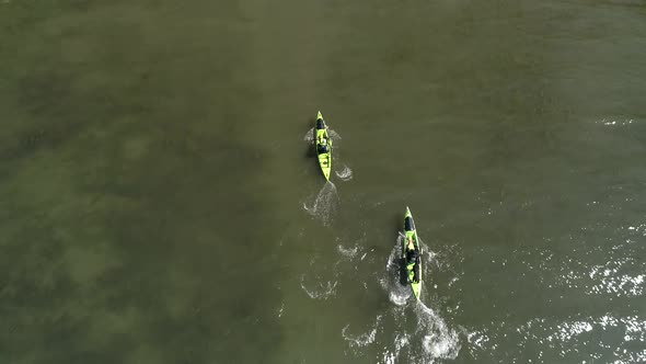 Overhead Aerial Of 2 Kayakers And Dog Paddling Shallow Ocean Water