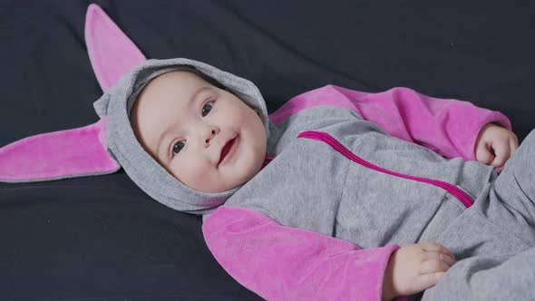 Cute Baby Smiling and Looking in the Camera Close Up. Little Kid in Bunny Costume, Top View.