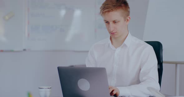 Businessman Typing on Laptop in Office