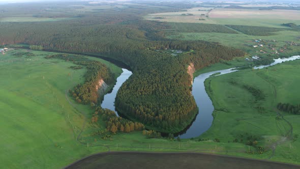 Aerial View of the River with a Rock and Forest on the Banks