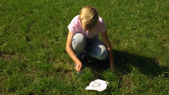 Boy Trying to Make Fire With Magnifier and Paper, Tips for Surviving in Forest