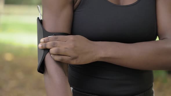 Wearing armband. Beautiful black athlete getting ready to run-slow motion