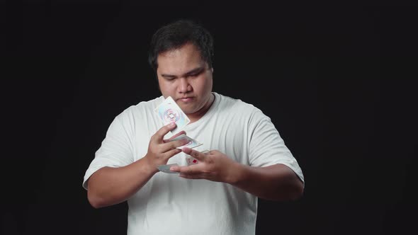 Asian Man Showing His Trick With Cards, Cardistry On Black Background