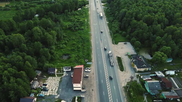 Cars and Trucks are Driving Fast Along the Highway Aerial View