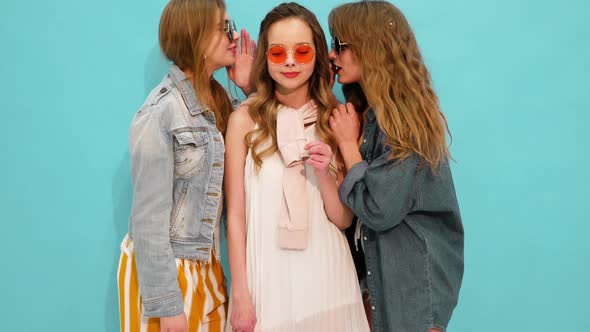 Three young beautiful smiling hipster girls in trendy summer casual clothes