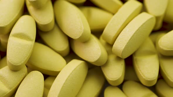 Bright Yellow Antipyretic Tablets Lie Together and Rotate Closeup